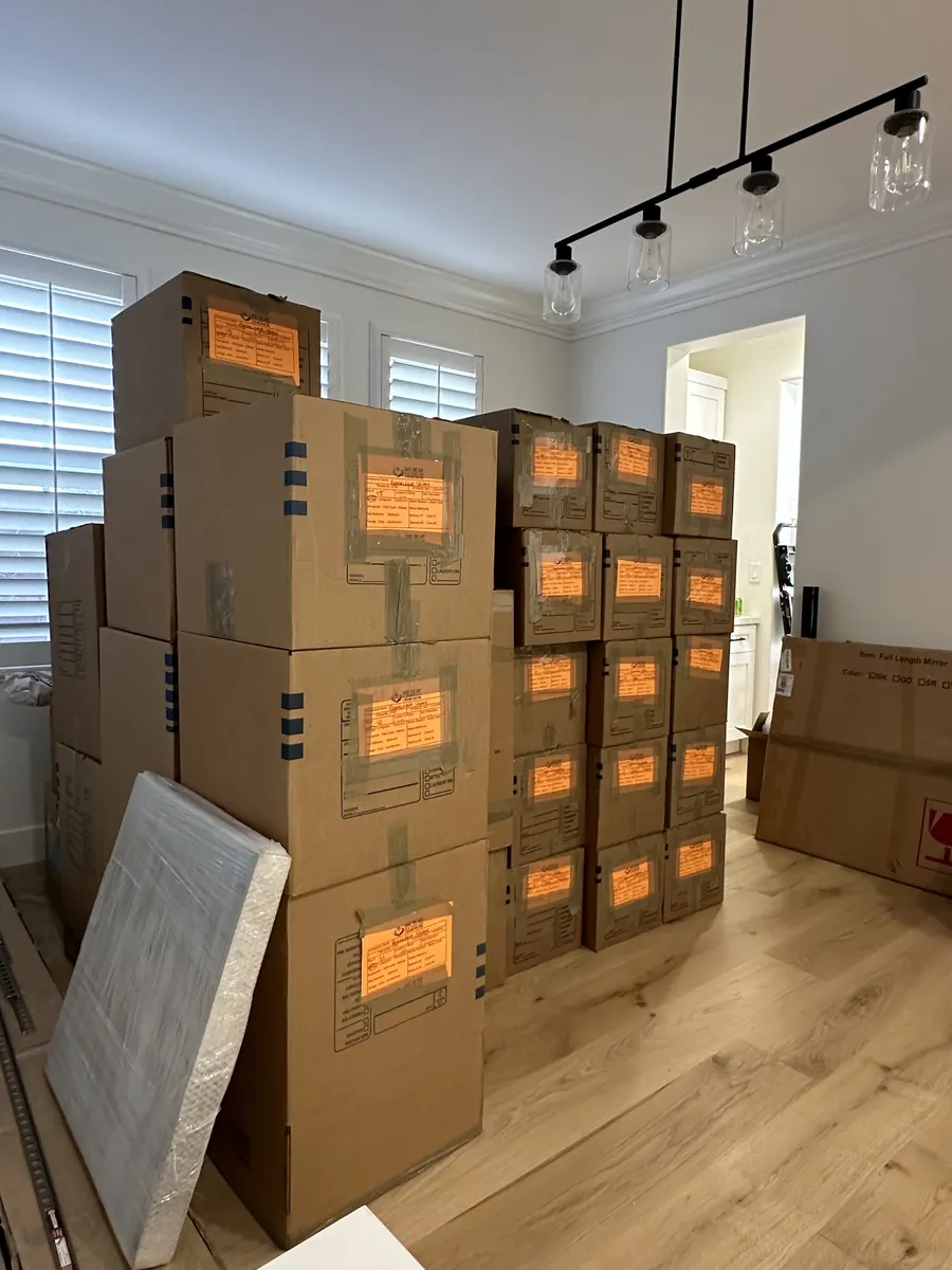 Plastic-wrapped mattress and inventory-labeled boxes staged during a contents pack-out
