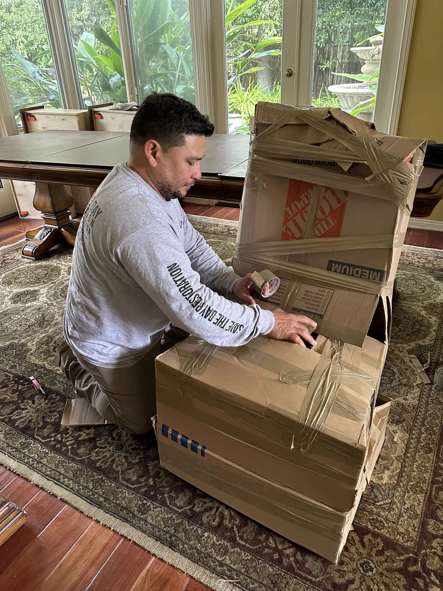 Restoration technician taping a packed stack of contents boxes during an emergency pack-out