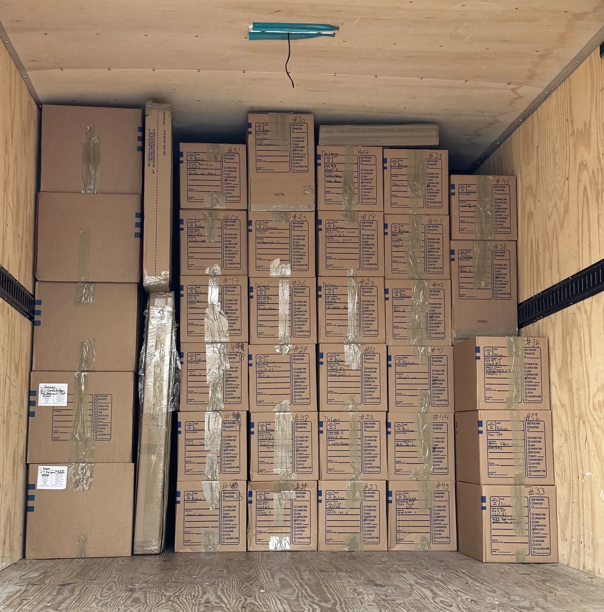 Rows of labeled, inventoried contents cartons loaded into a Save The Day box truck