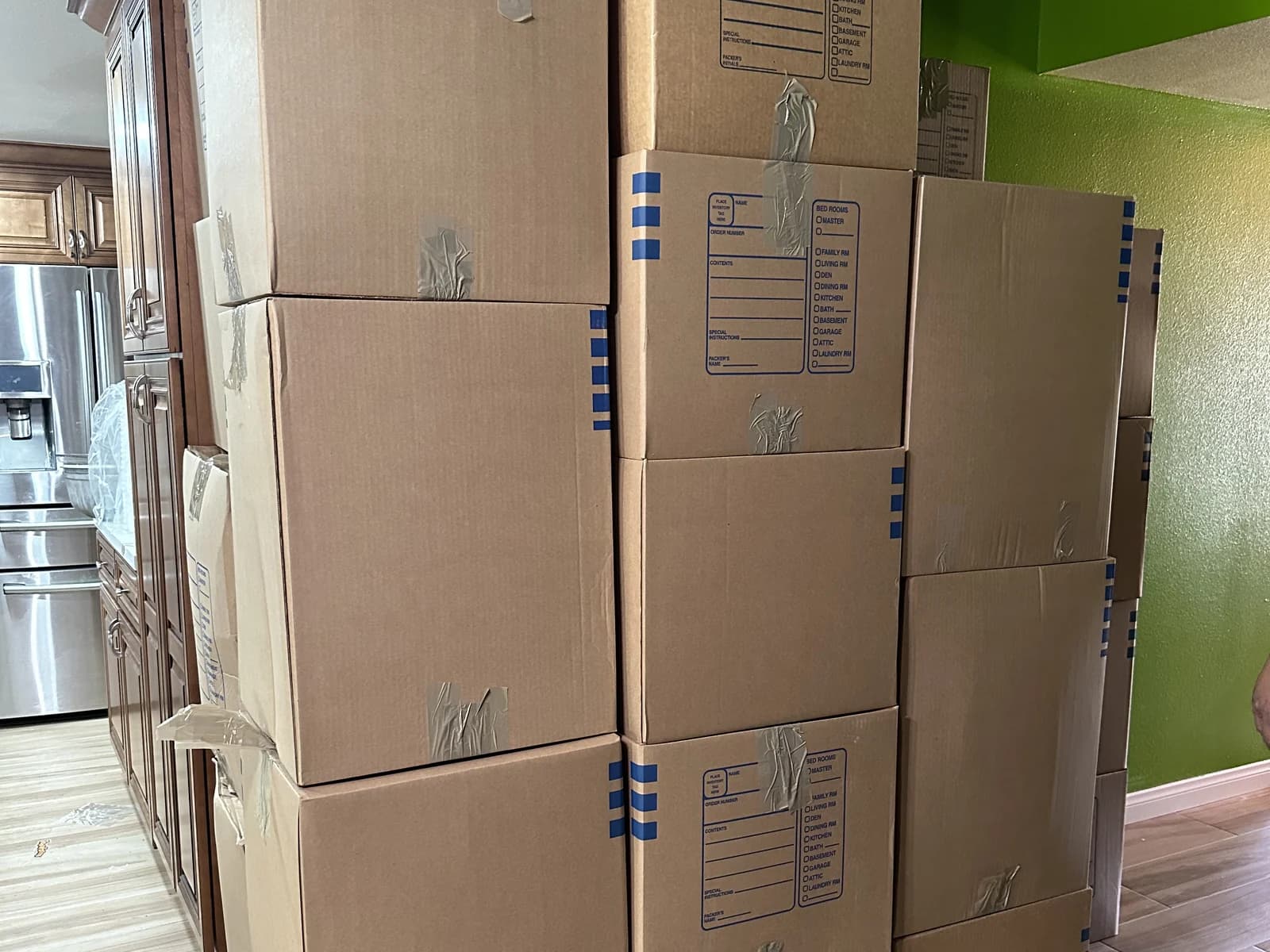 Cartons packed, sealed and stacked by hand in a client's kitchen during a room-by-room pack-out