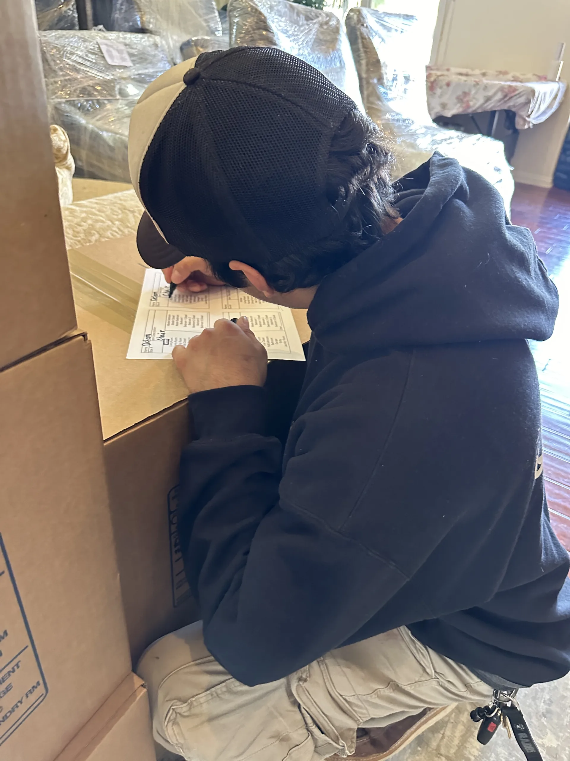 Crew member documenting household items on a written inventory checklist during a contents loss