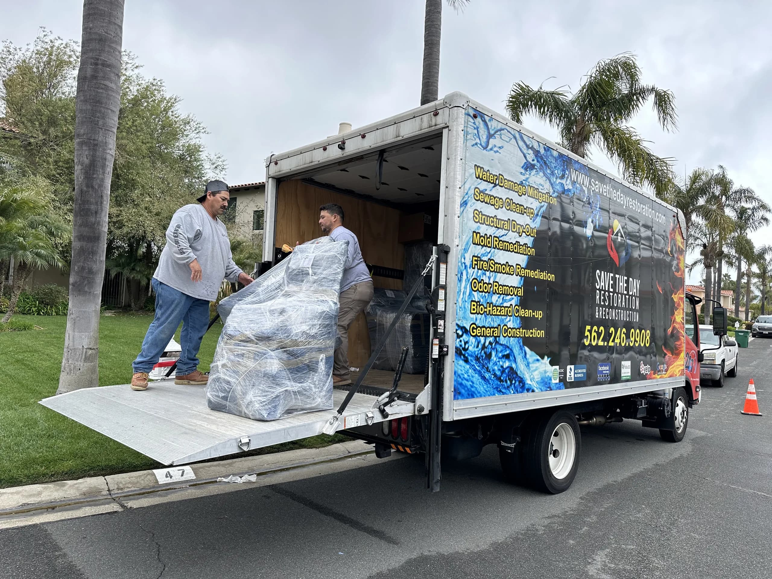 Save The Day crew loading wrapped furniture into a branded box truck during a residential contents pack-out